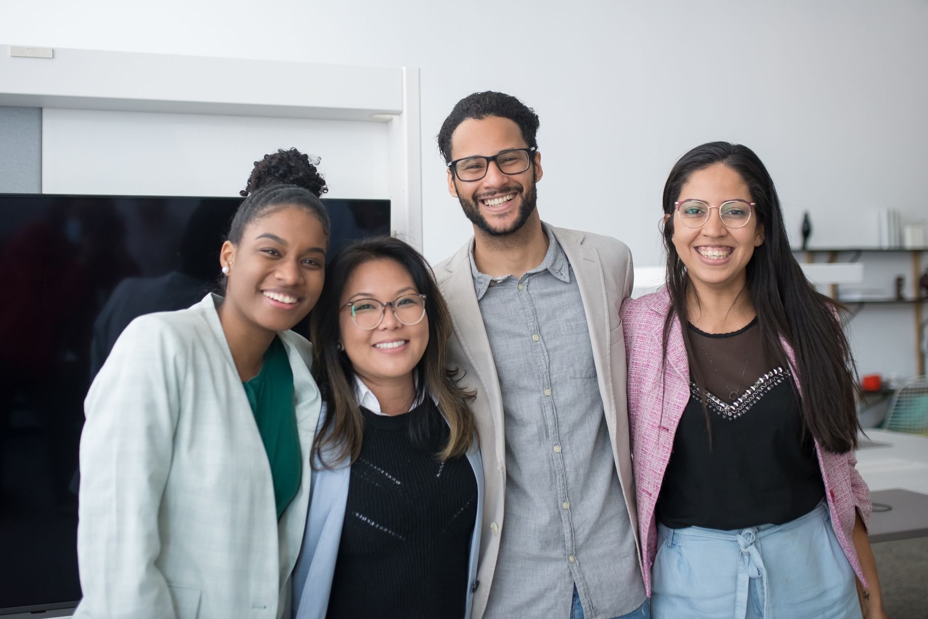 Diverse team of coworkers smiling in a modern office — group training participants